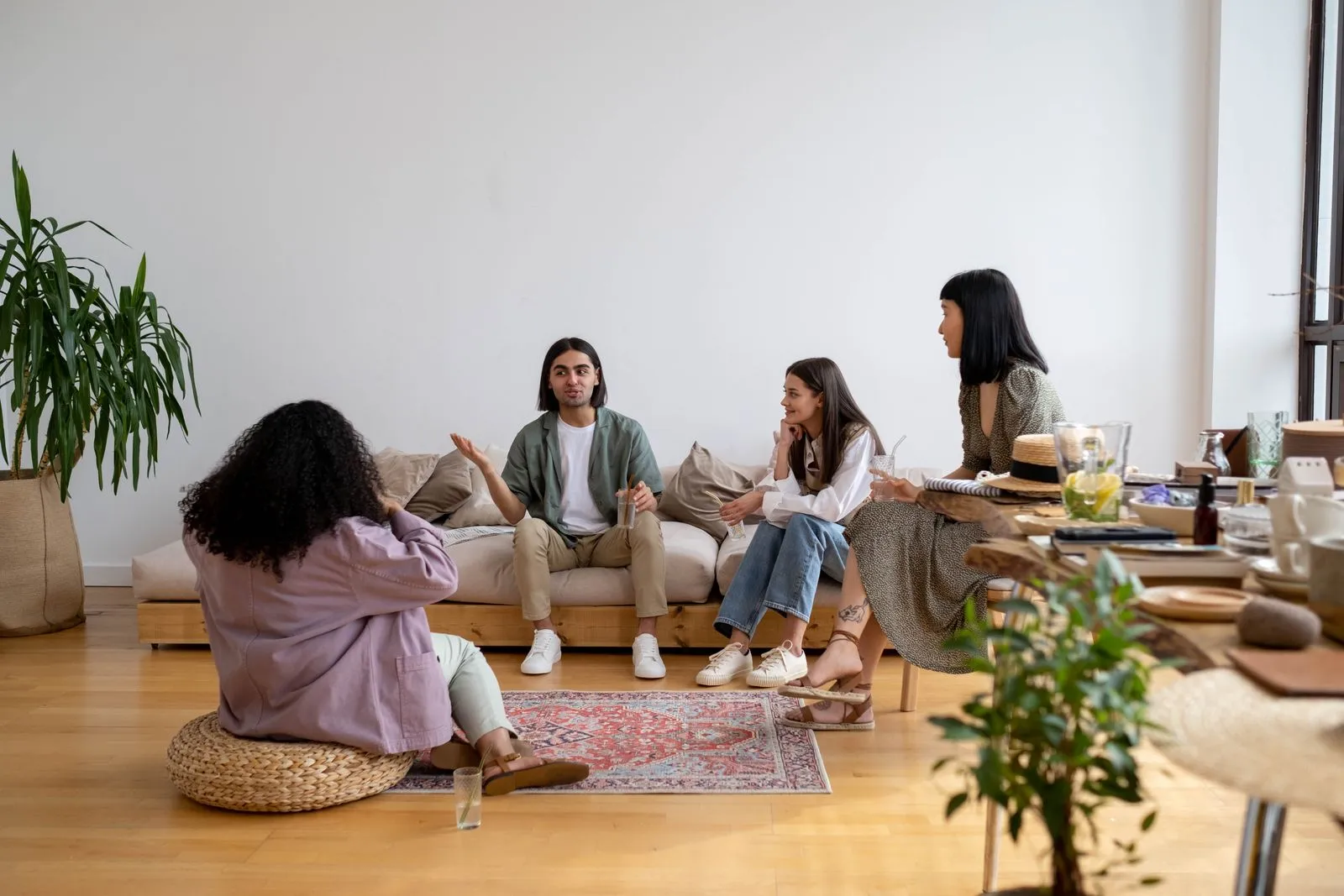 A small group talking together in a bright, relaxed living room.