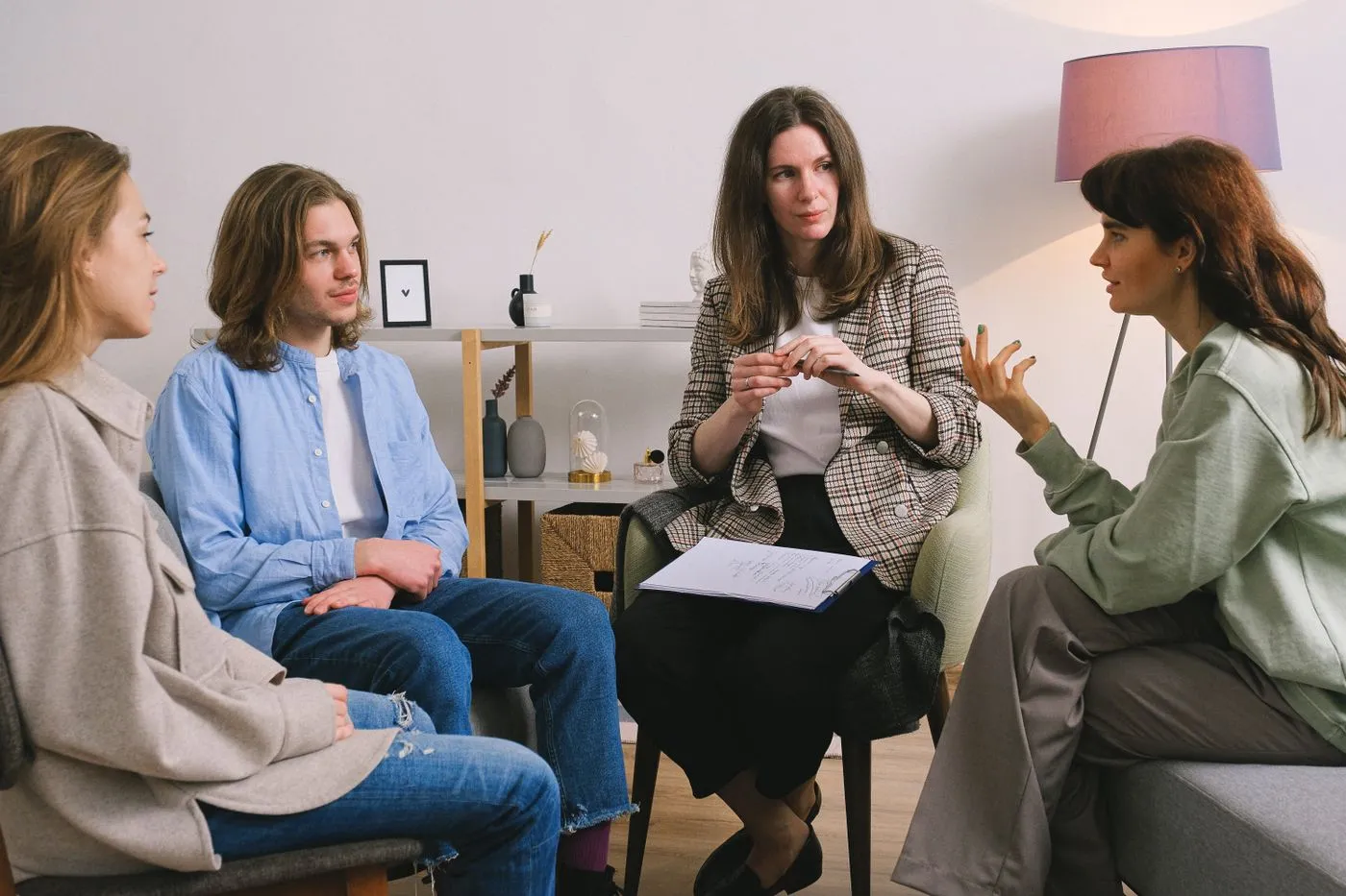 A facilitator holding notes while guiding a small group conversation.